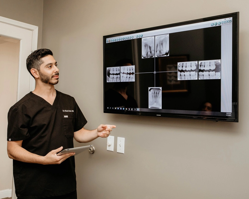 dr. anthony mark saad showing digital x-ray to a patient